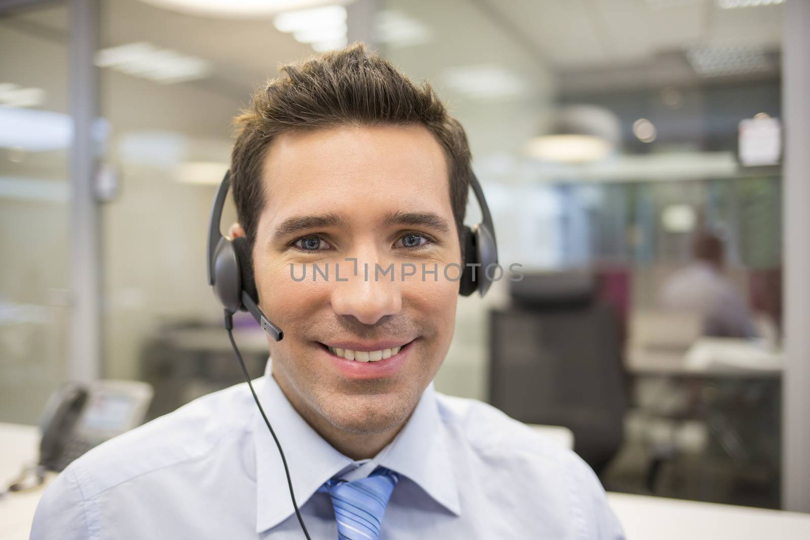 Businessman in the office on the phone with headset by LDProd