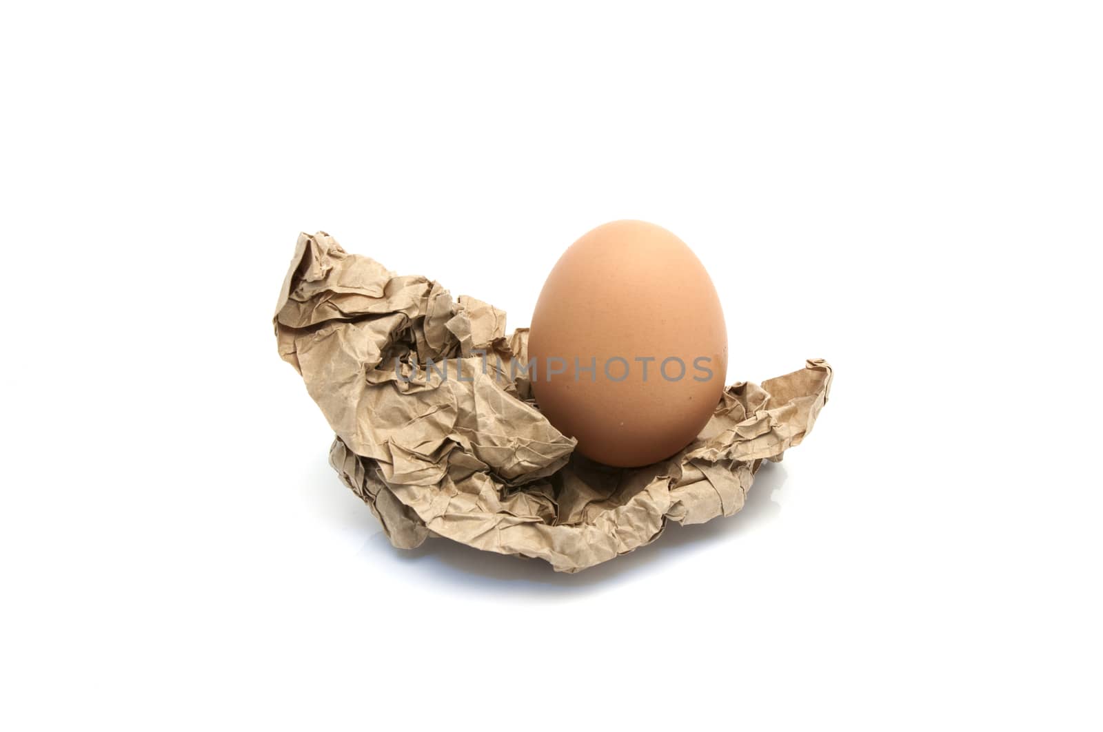 Egg in crumpled wrapping gray paper and white background