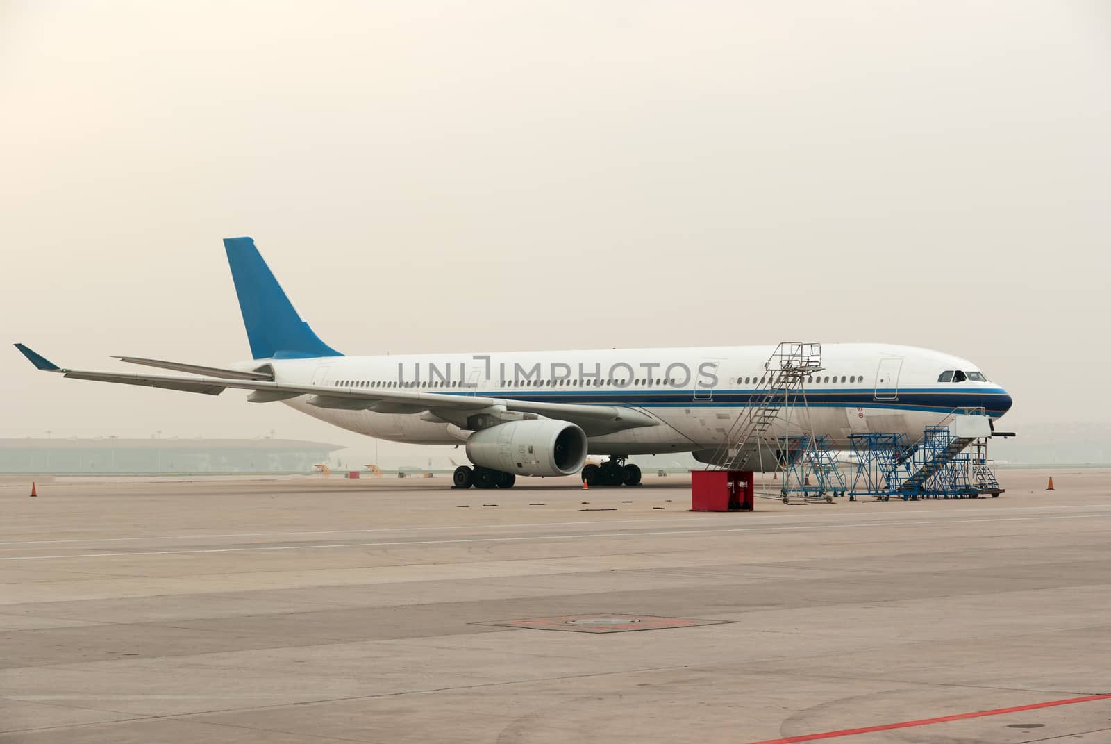 Commercial airline on platform airport during a cloudy day