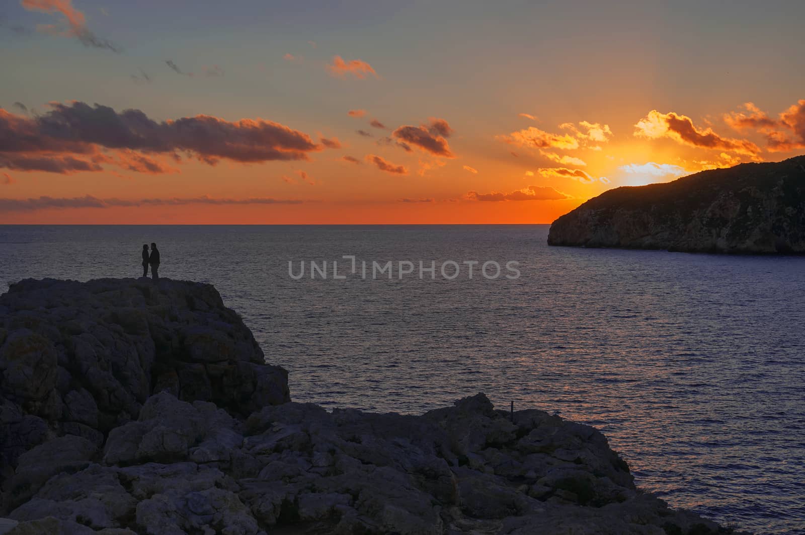 Romantic couple on a cliff at sunset, Majorca, Balearic islands, Spain.
