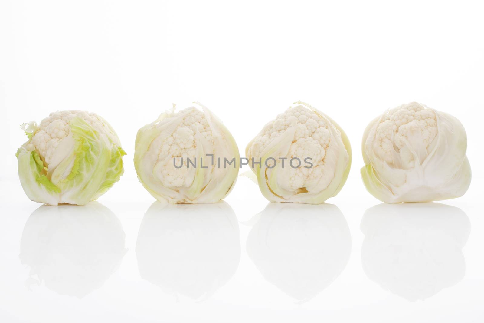 Four baby cauliflower isolated on white background with reflection. Healthy culinary vegetable. 