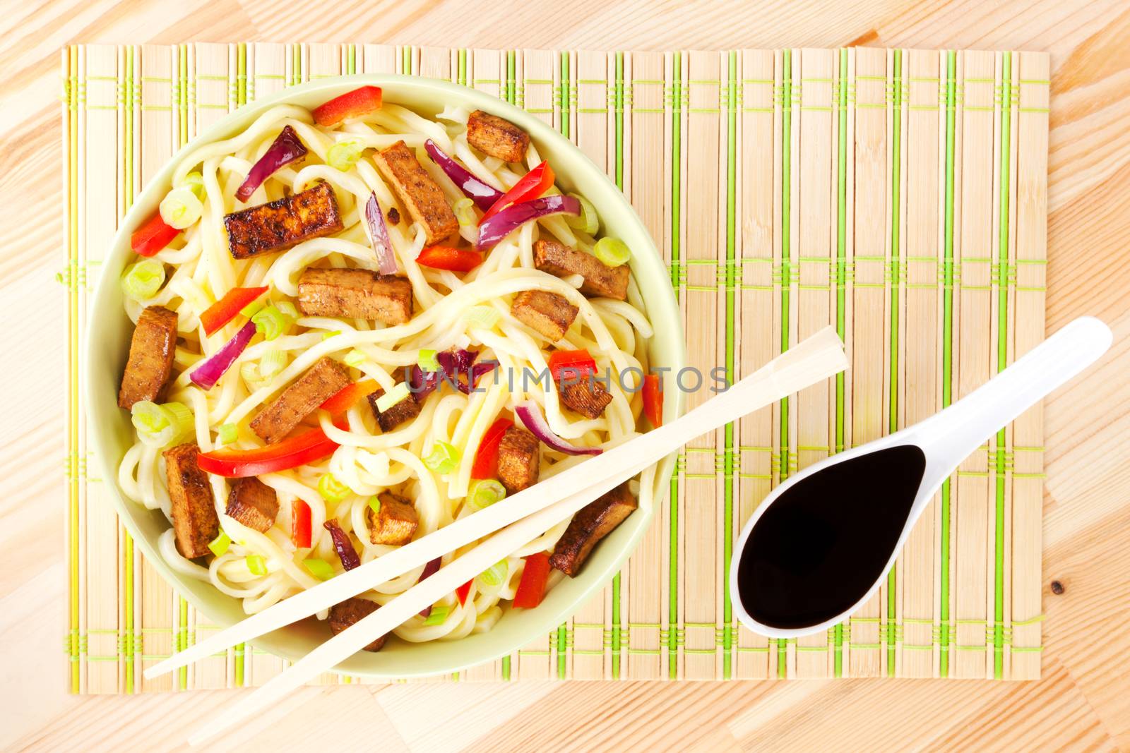 Noodles with tofu and vegetable, chopsticks and soy sauce. Asian food concept.