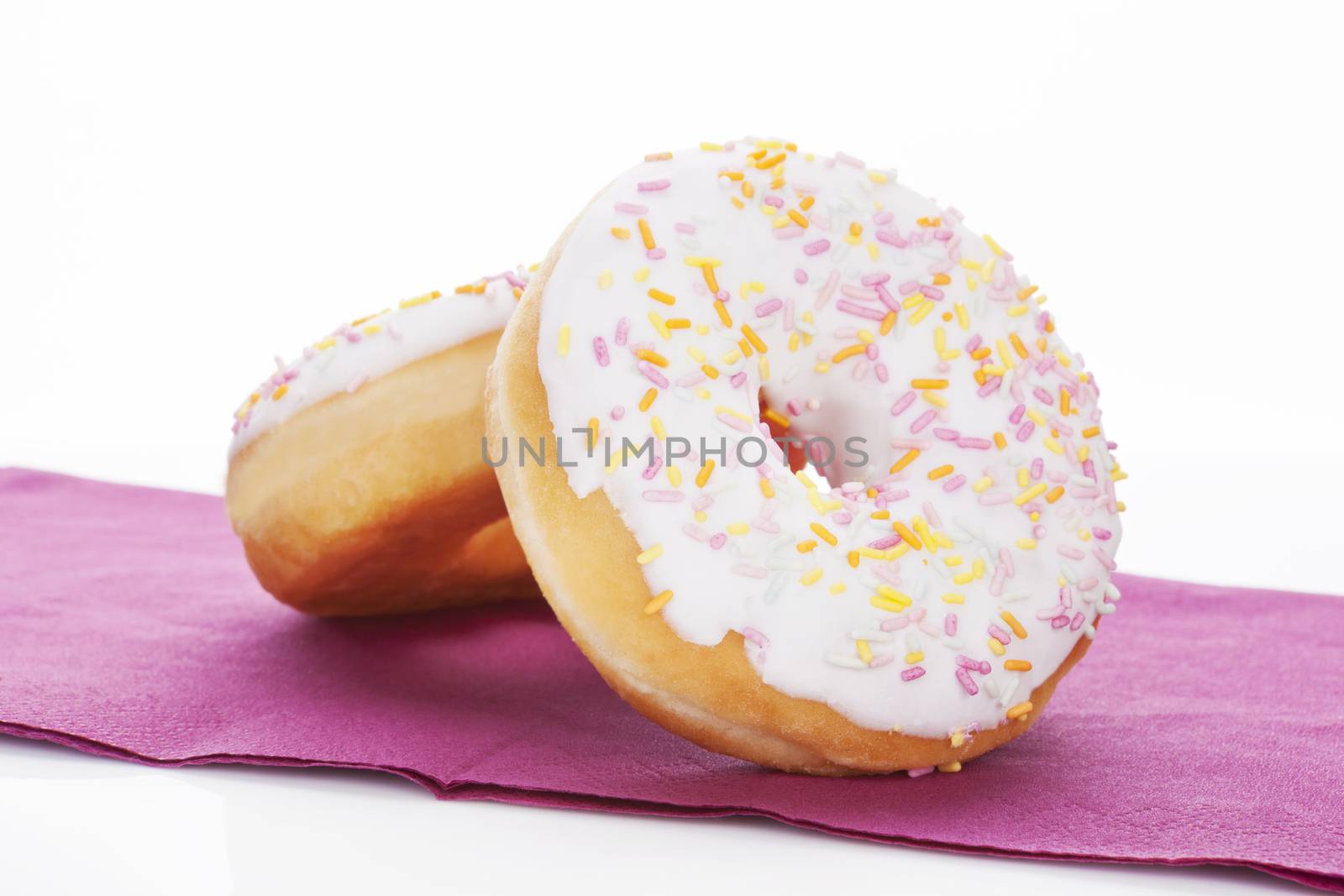 Colorful donuts on kitchen cloth on white background. Sweet dessert concept.