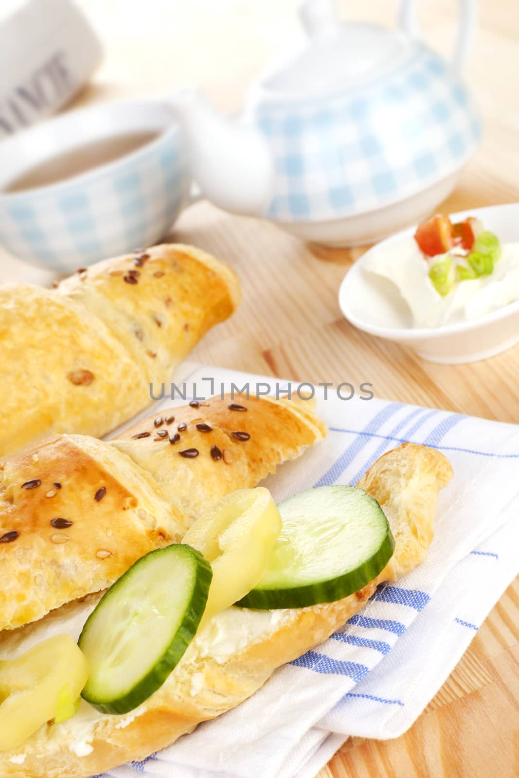 Luxurious delicious breakfast background. Croissatn with fresh vegetable, tea and financial times in background. Good morning concept.