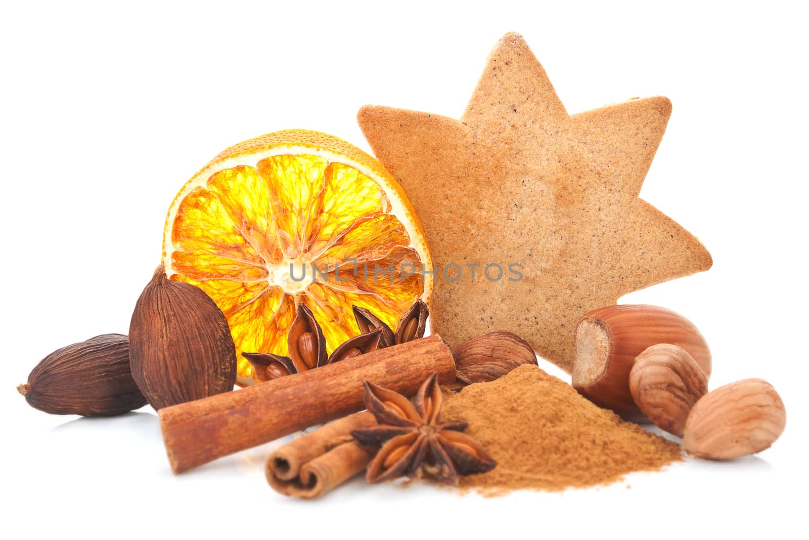 Gingerbread star shaped cookie and orange slice. Aromatic culinary spices and various nuts, cinnamon, anise and christmas background. Traditional christmas aromatic spices, fruits and cookies still life. 