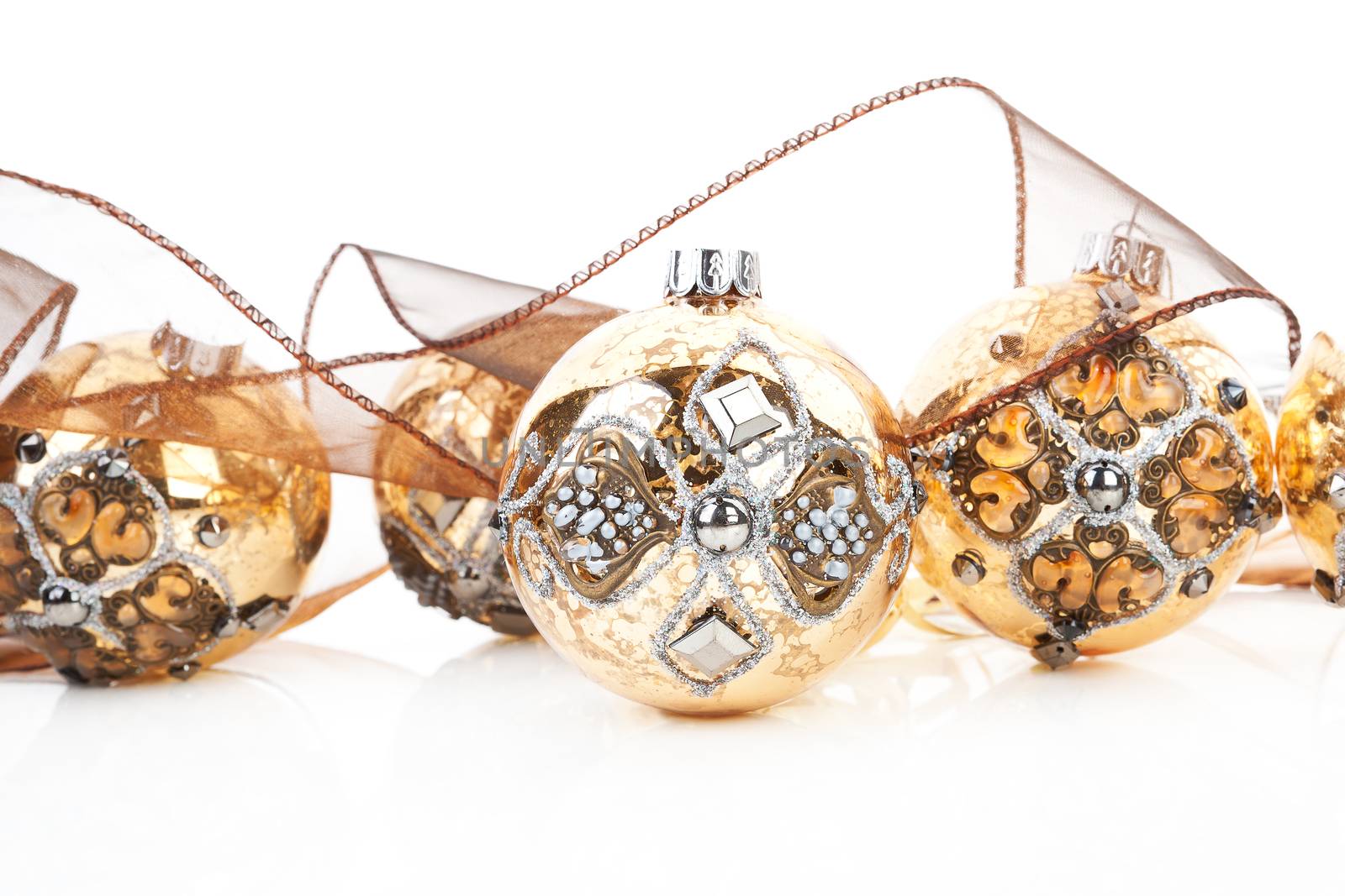 Luxurious antique golden christmas balls decorated with brown ribbon. Traditional festive xmas background.
