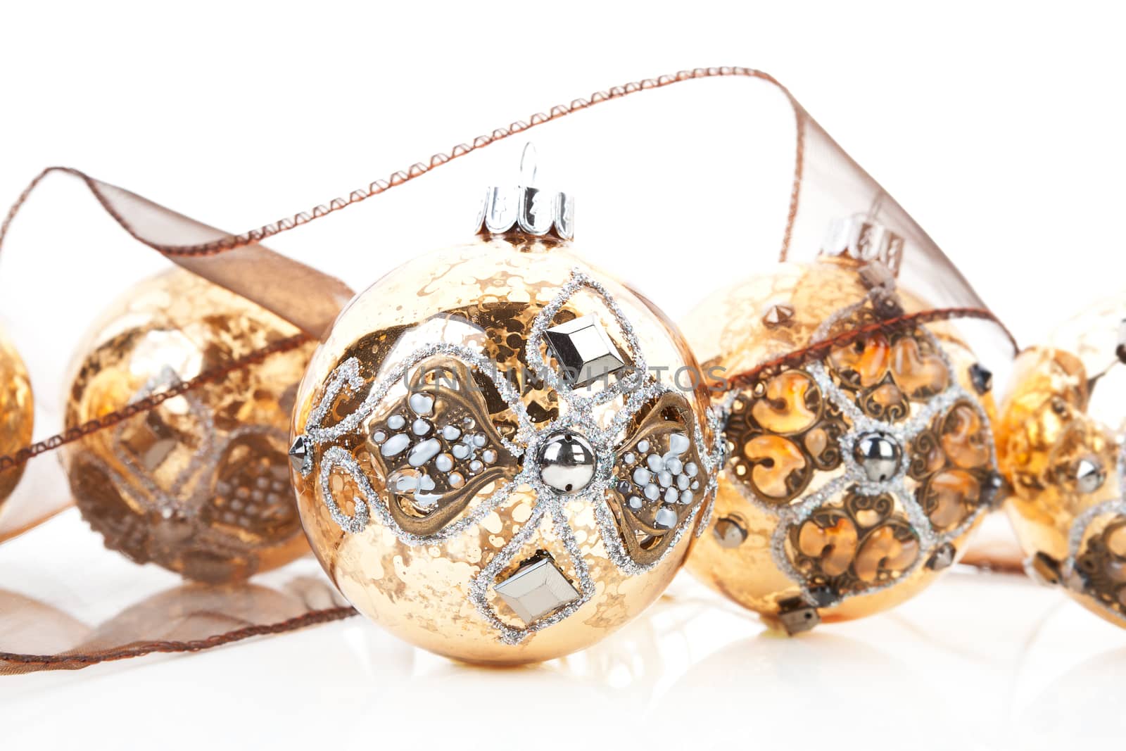 Luxurious christmas still life with antique golden baubles and brown ribbon on white background.