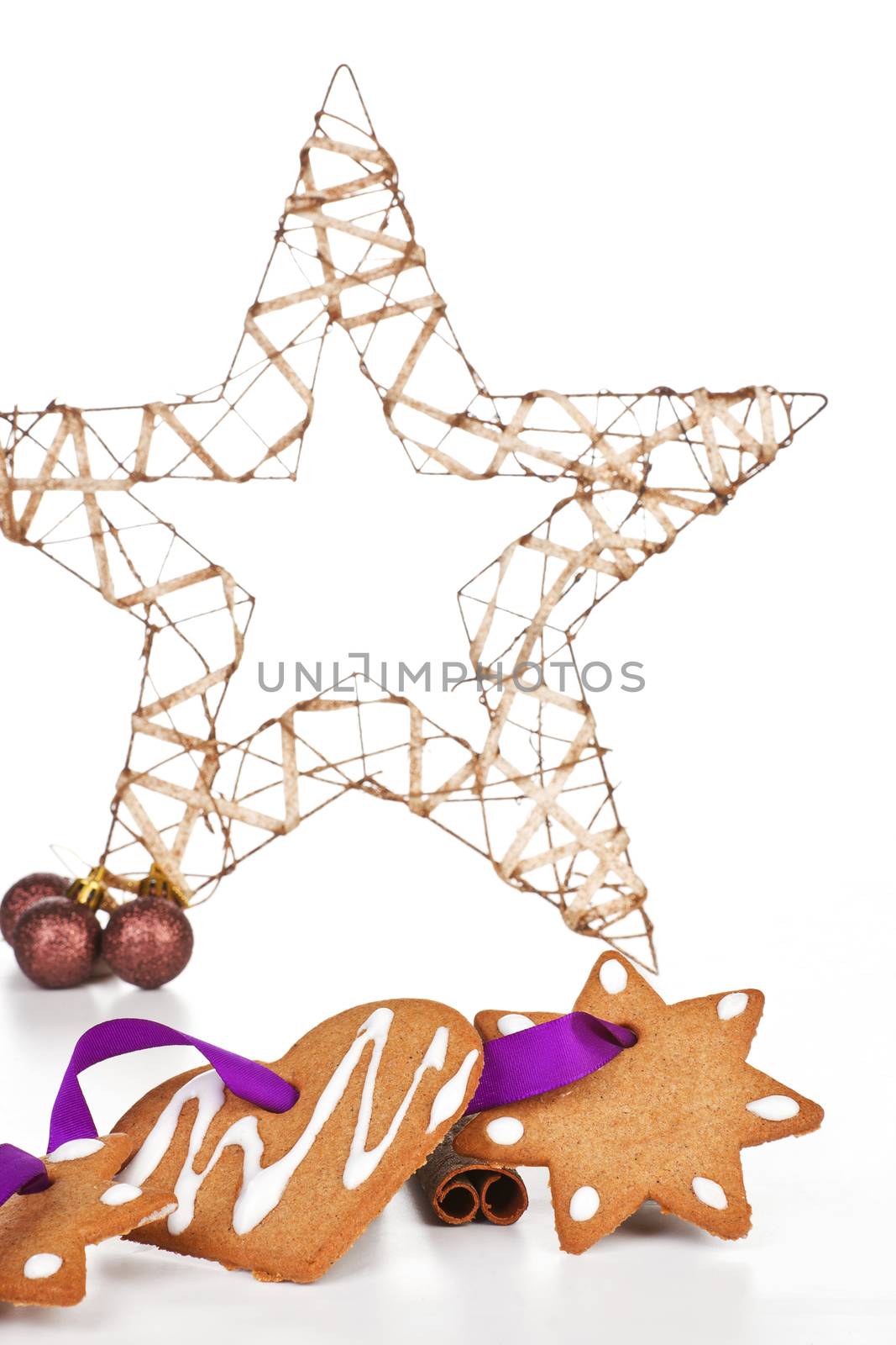 Homemade delicious gingerbread stars and heart with purple ribbon with big christmas star decoration. Temporary christmas background.