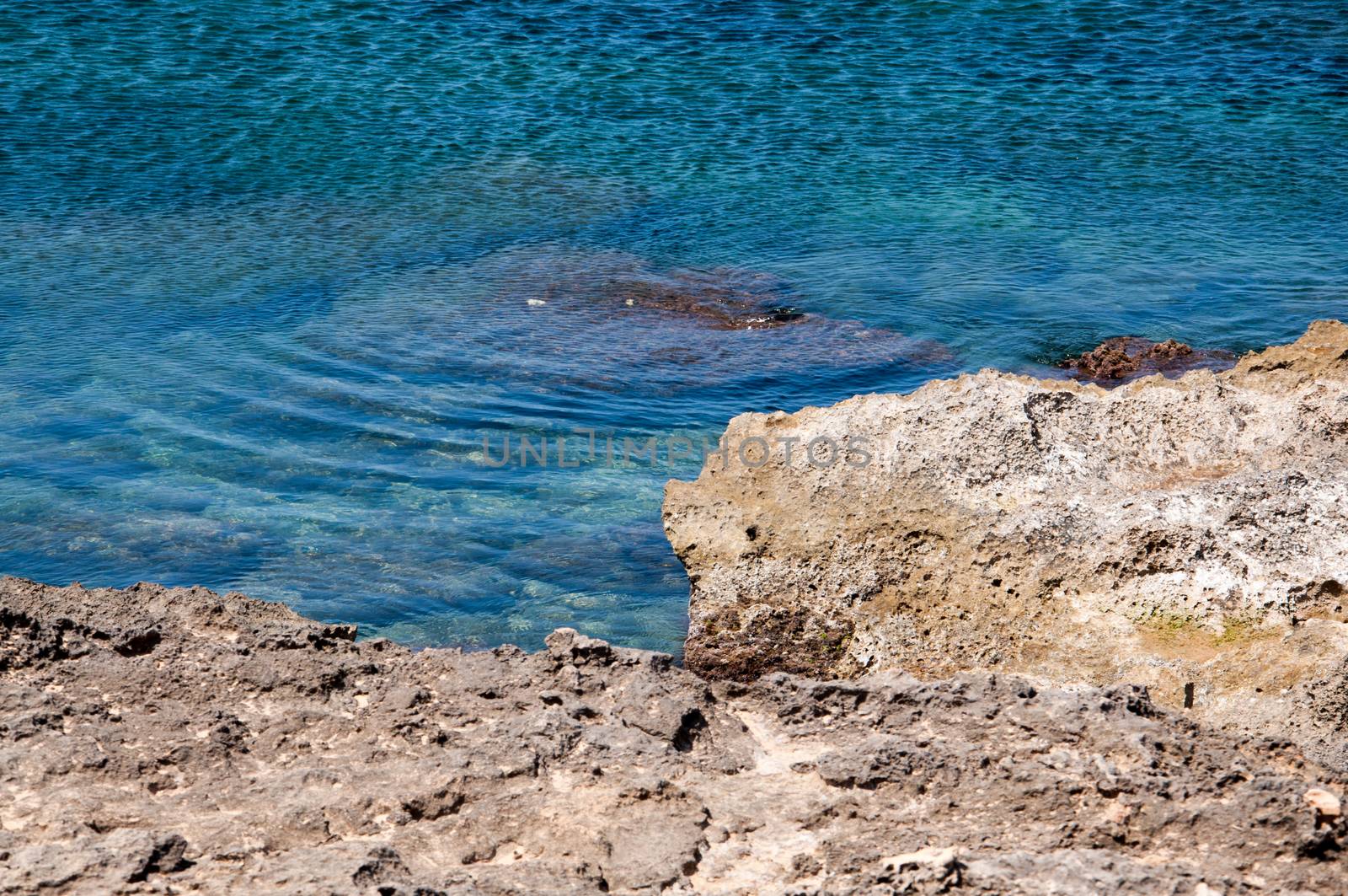 Azure water and yellow limestone rocks in the Mediterranean. Majorca, Balearic islands, Spain.