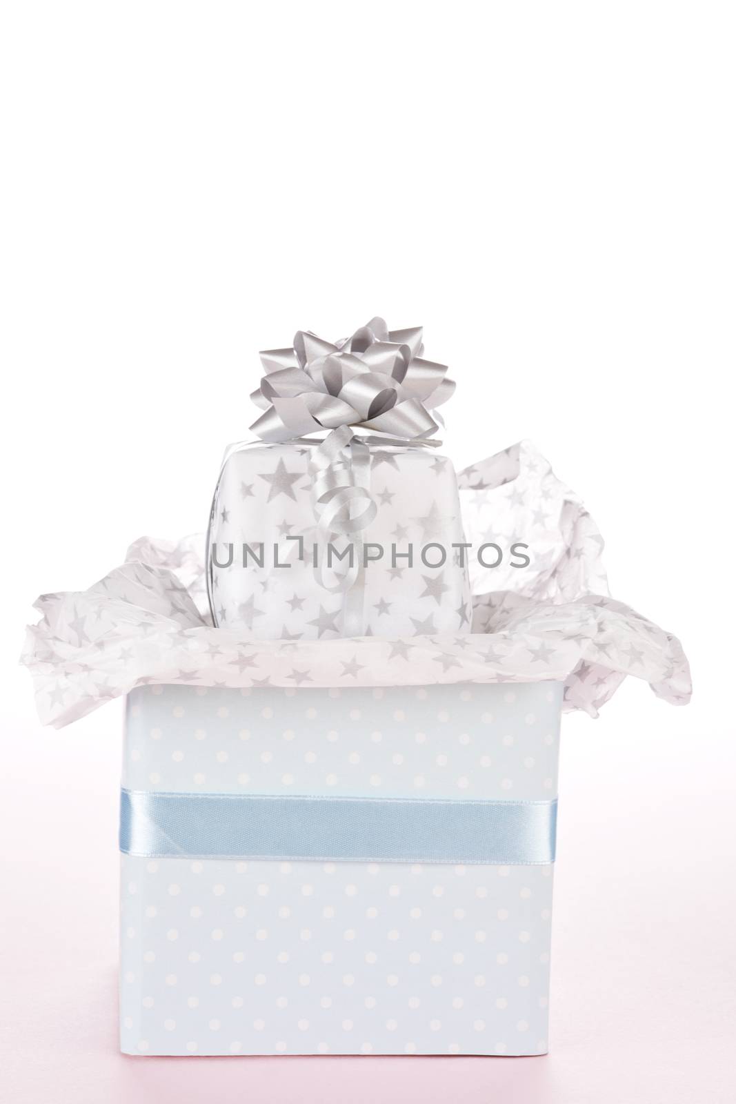 Luxurious gift with ribbon. Light festive background. by eskymaks