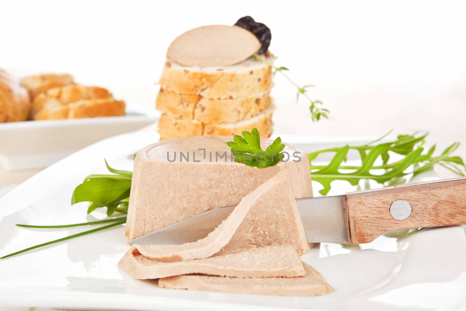 Delicious pate on white plate. Pastry in background. Culinary gourmet eating.