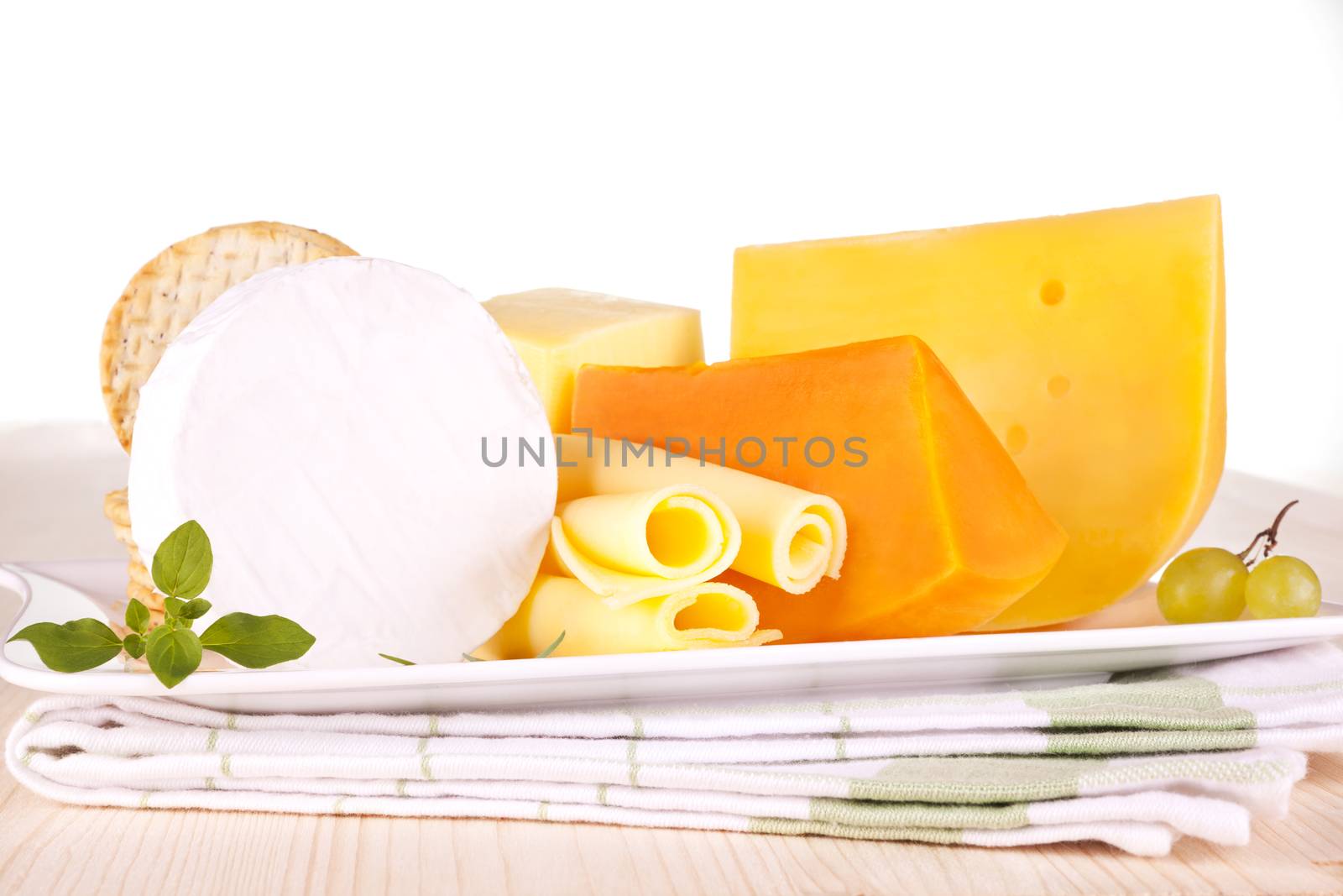 Luxurious cheese collection on white tray on kitchen cloth. Luxurious culinary eating.