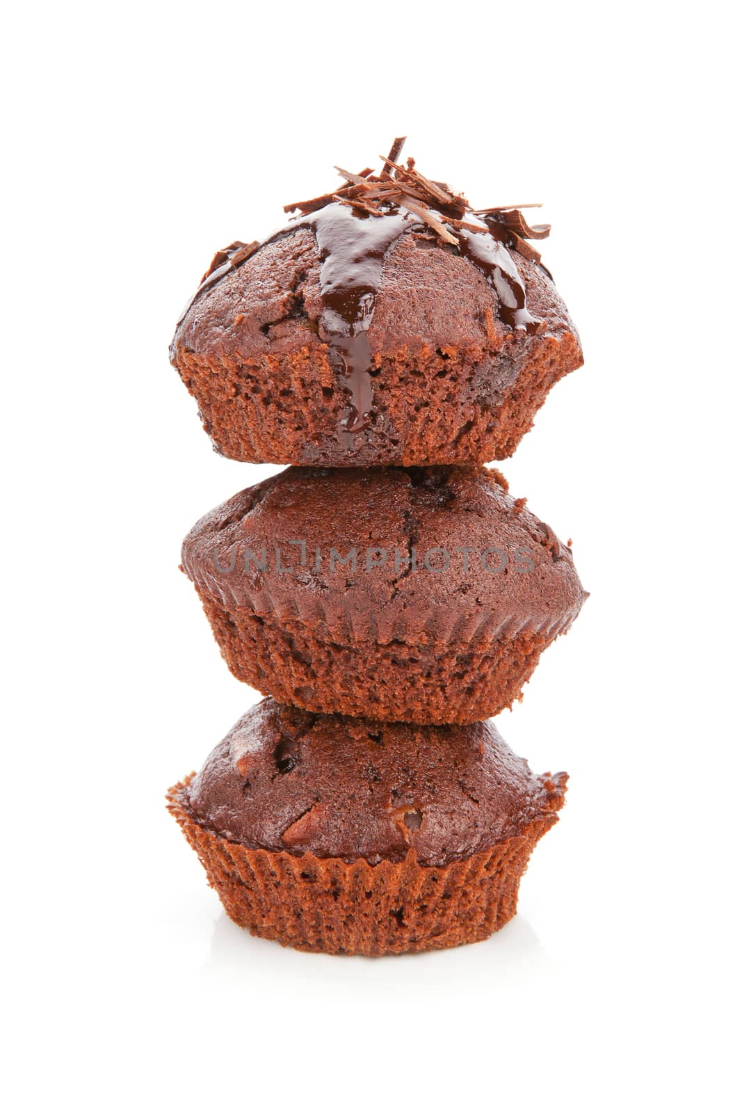 Three delicious chocolate muffins arranged on each other isolated on white background. 