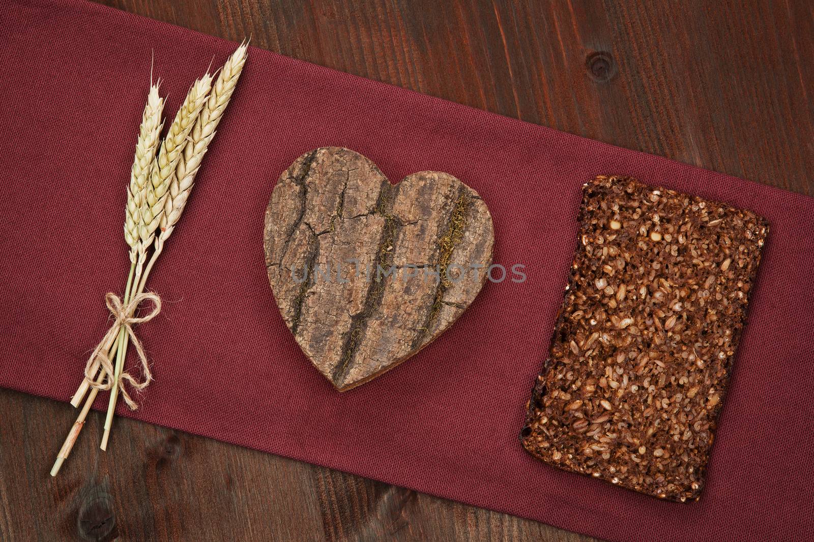 I love whole grain dark bread made of wheat, wooden heart and dark bread slice. Healthy eating concept.
