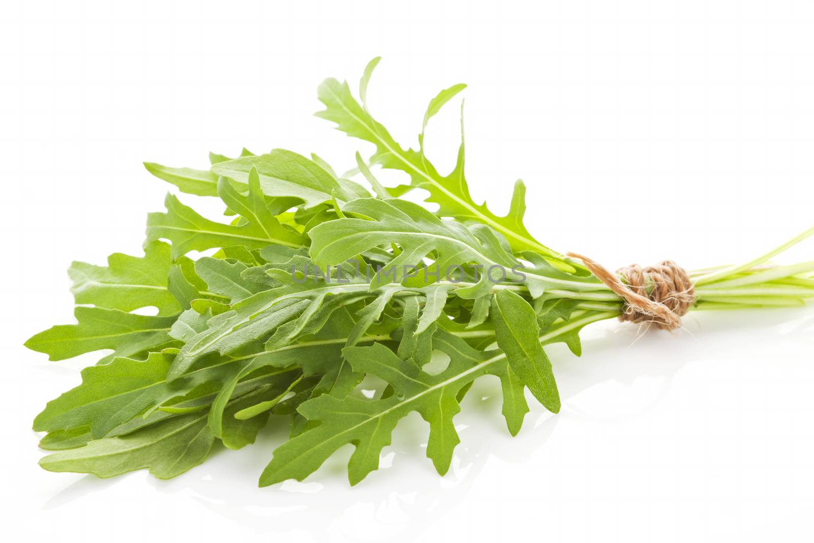 Fresh organic arugula bundle bound with brown twine isolated on white background.