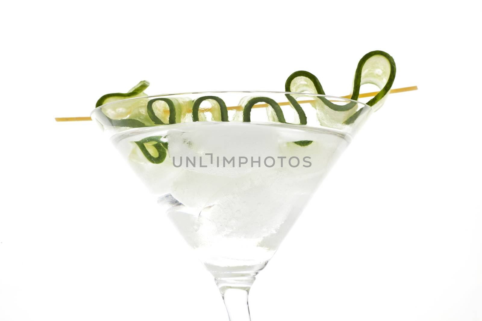 Delicious transparent white cocktail with ice and cucumber garnish detail isolated on white background. Luxurious drink.