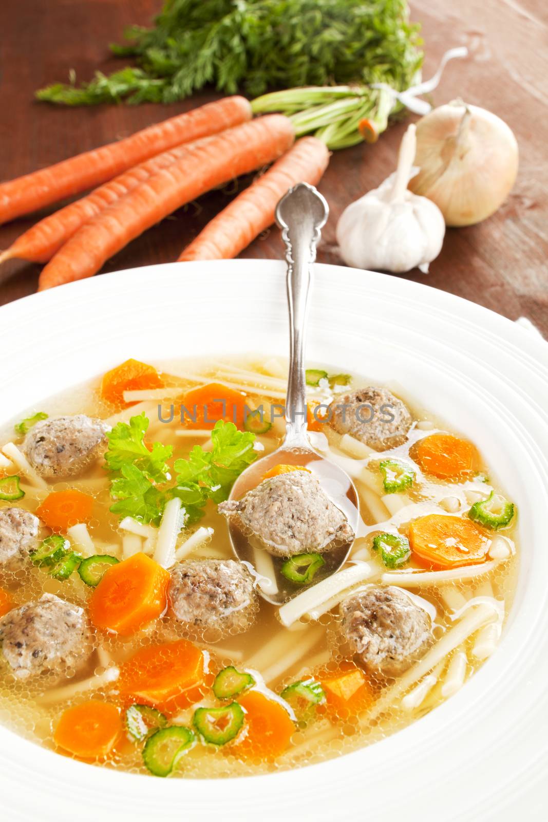 Delicious seasonal vegetable soup with fresh vegetable in background. Healthy eating.