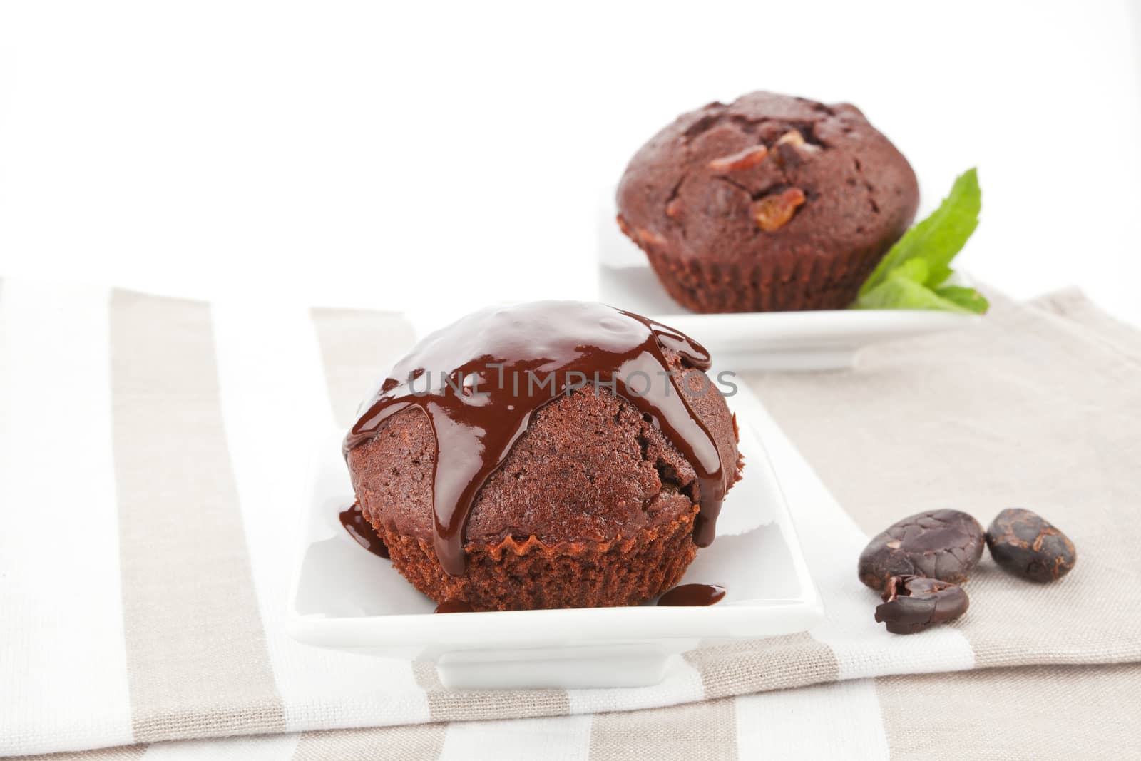 Chocolate muffins on kitchen cloth. by eskymaks