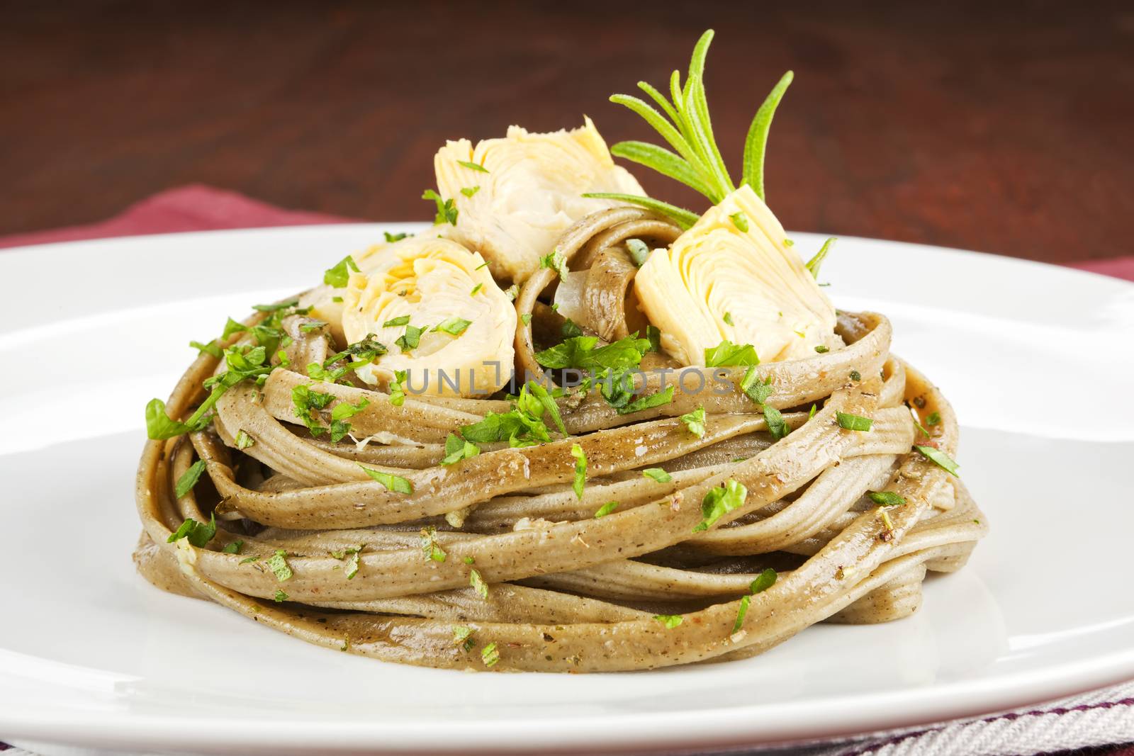 Tagliatelle with vegetable and fresh herbs on white plate. Exquisite dining.