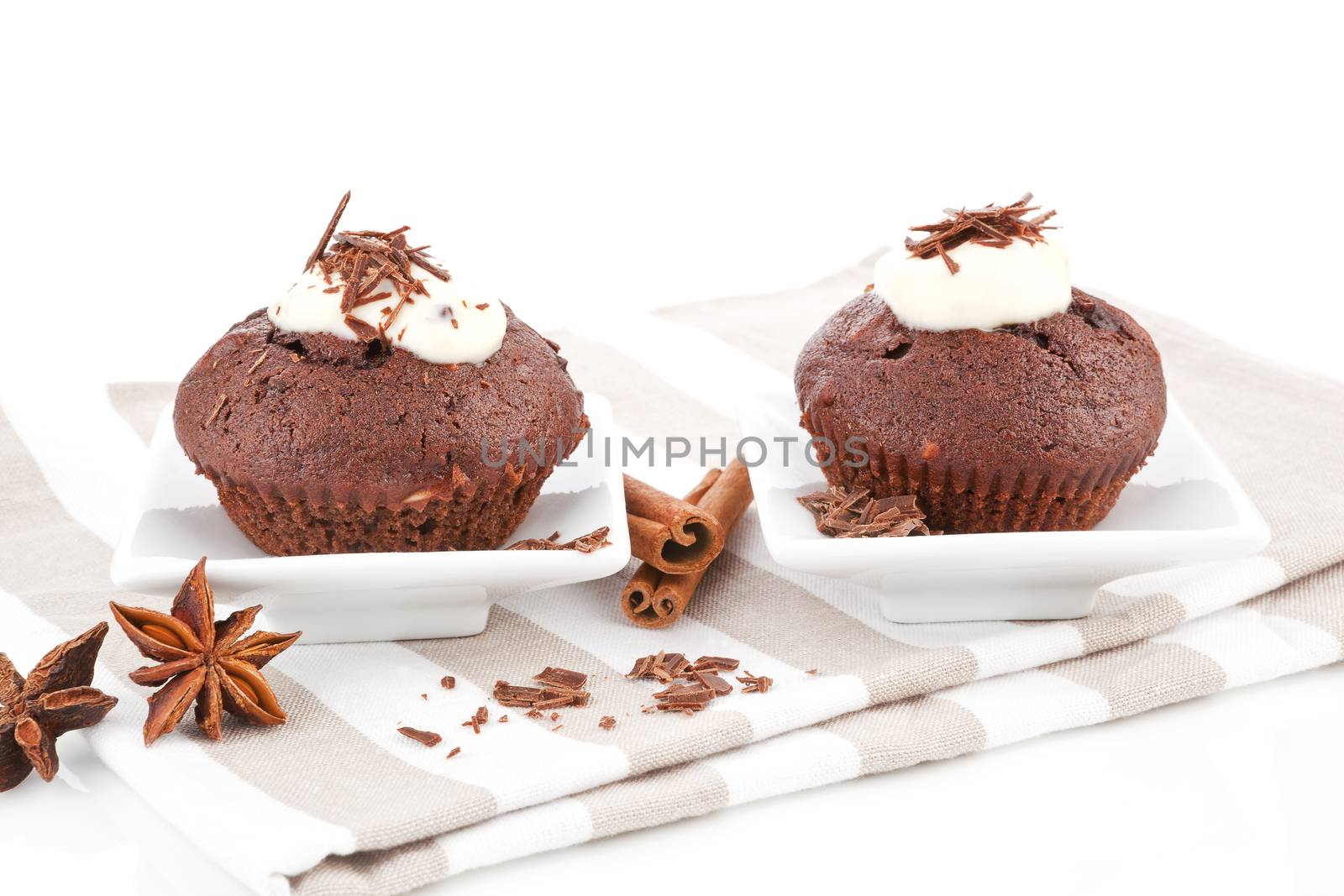 Two muffins with cream and chocolate. Luxurious sweets concept.