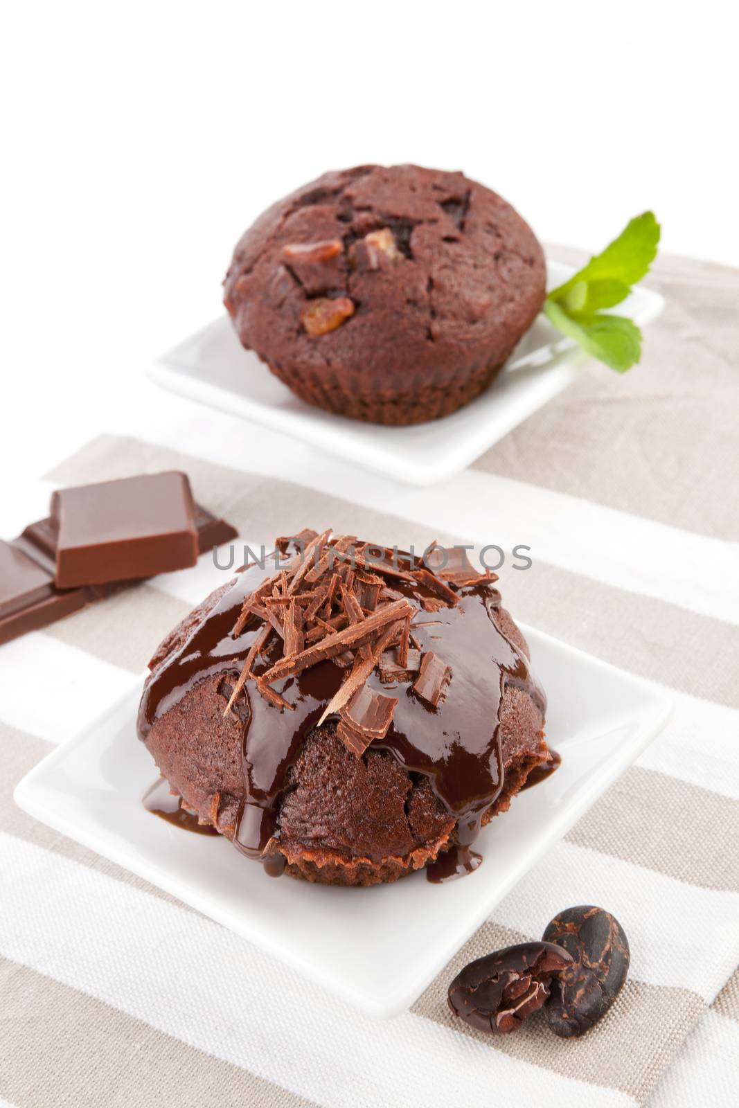 Delicious chocolate muffin with chocolate crop, fresh mint leaf and chocolate. Chocolate background.