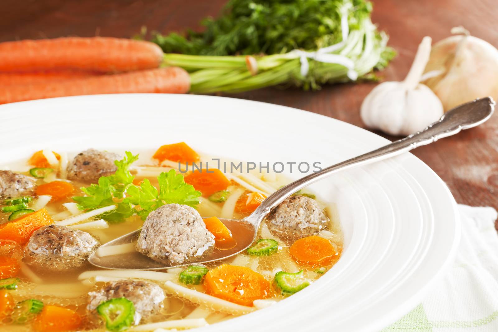 Delicious seasonal vegetable soup with fresh vegetable in background. Healthy eating.