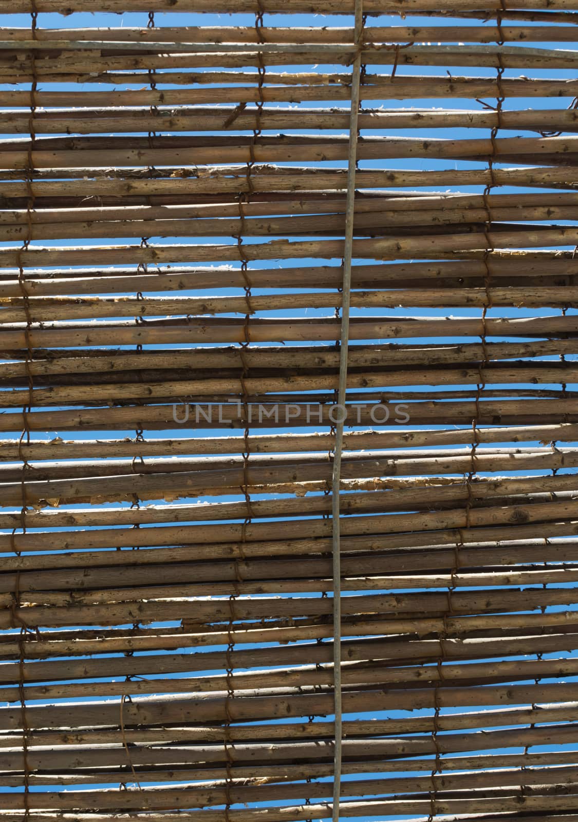 Bamboo shade as sun protection and blue sky.