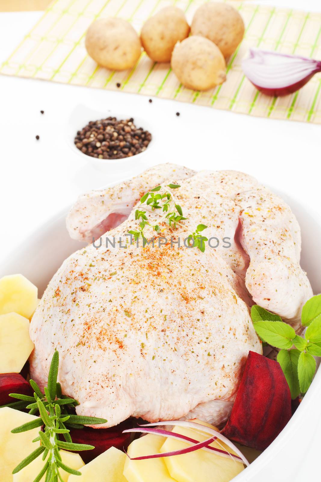 Delicious chicken with fresh herbs and vegetable in baking dish prepared for baking. Poultry.