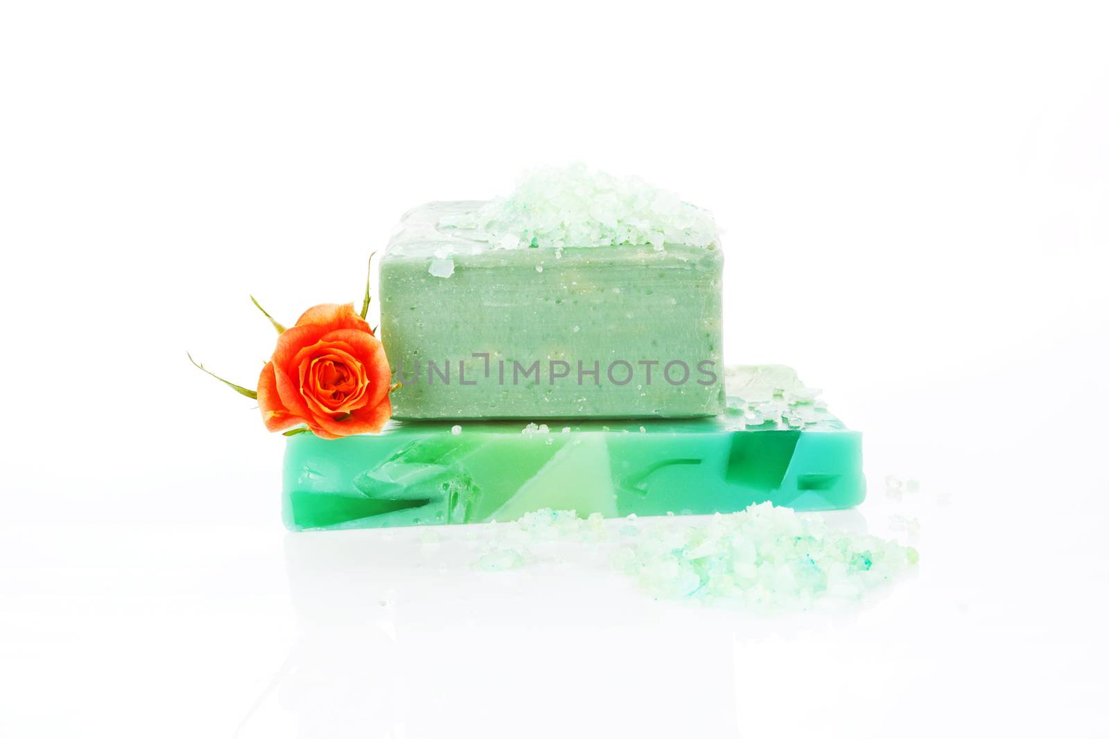 Wellness background. Organic soap bar with bath salt and rose isolated on white background.