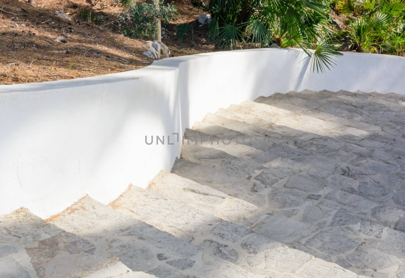 Curved staircase with white stucco wall.