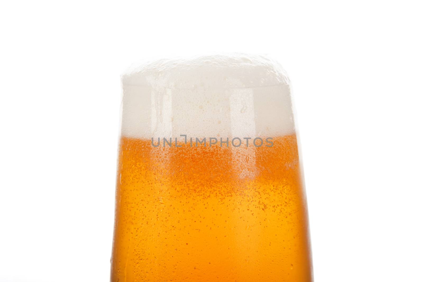Lager beer in glass with froth isolated on white. Hot summer background.