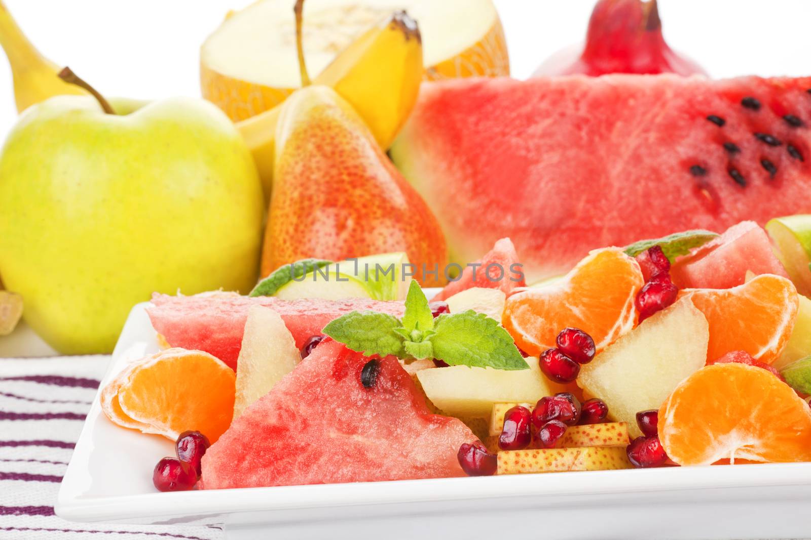Delicious colorful fruit salad close up. Fruits in background. Light summer food. The greatest wealth is health.  ~Virgil
