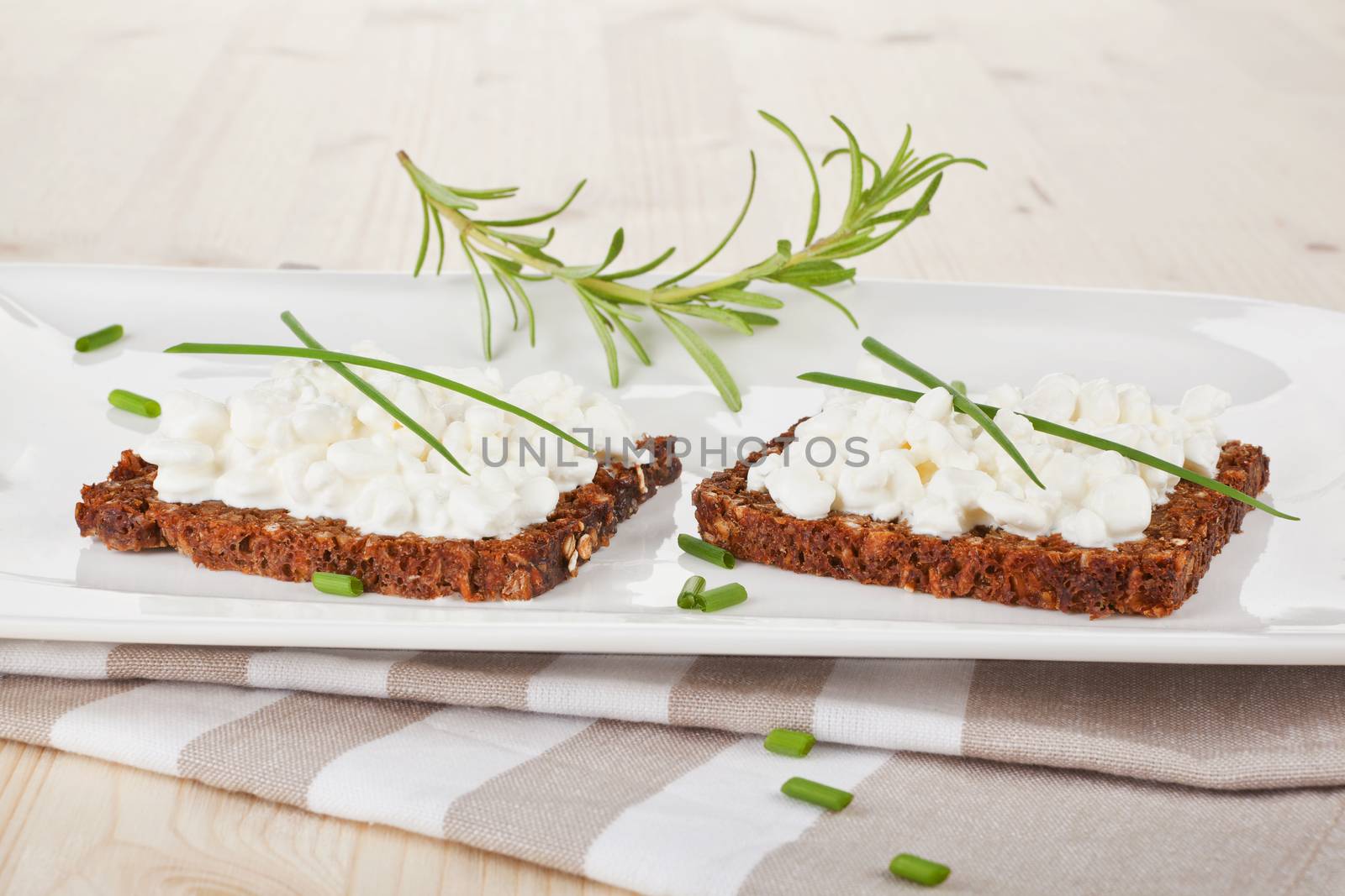 Luxurious black bread slices with cottage cheese on white plate. Healthy eating. 