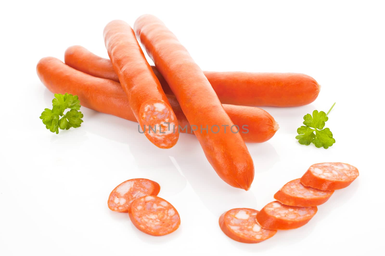 Luxurious sausages and slices isolated on white background. Unhealthy eating.