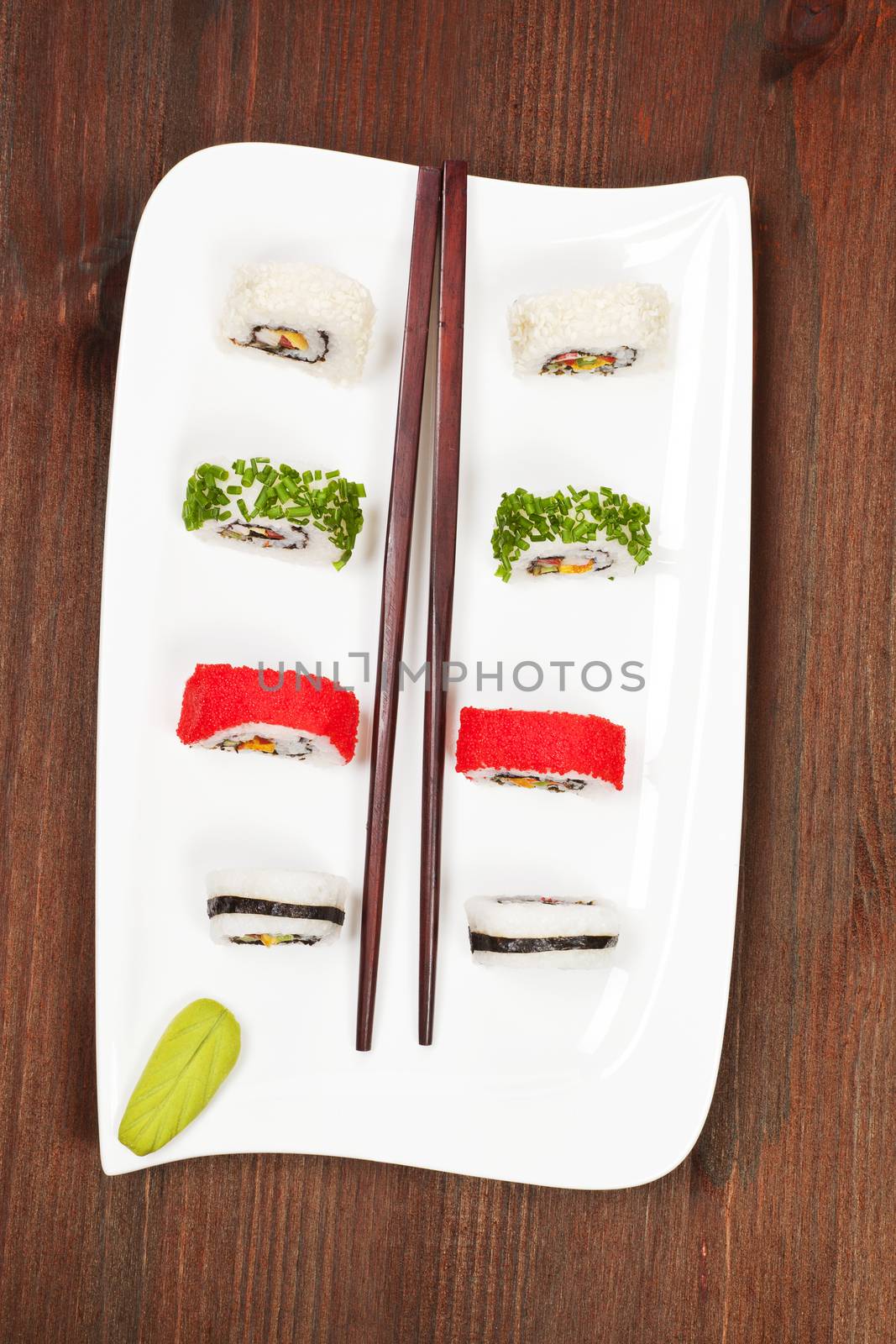 California sushi rolls with chive, sesame and caviar on white plate. Top view.