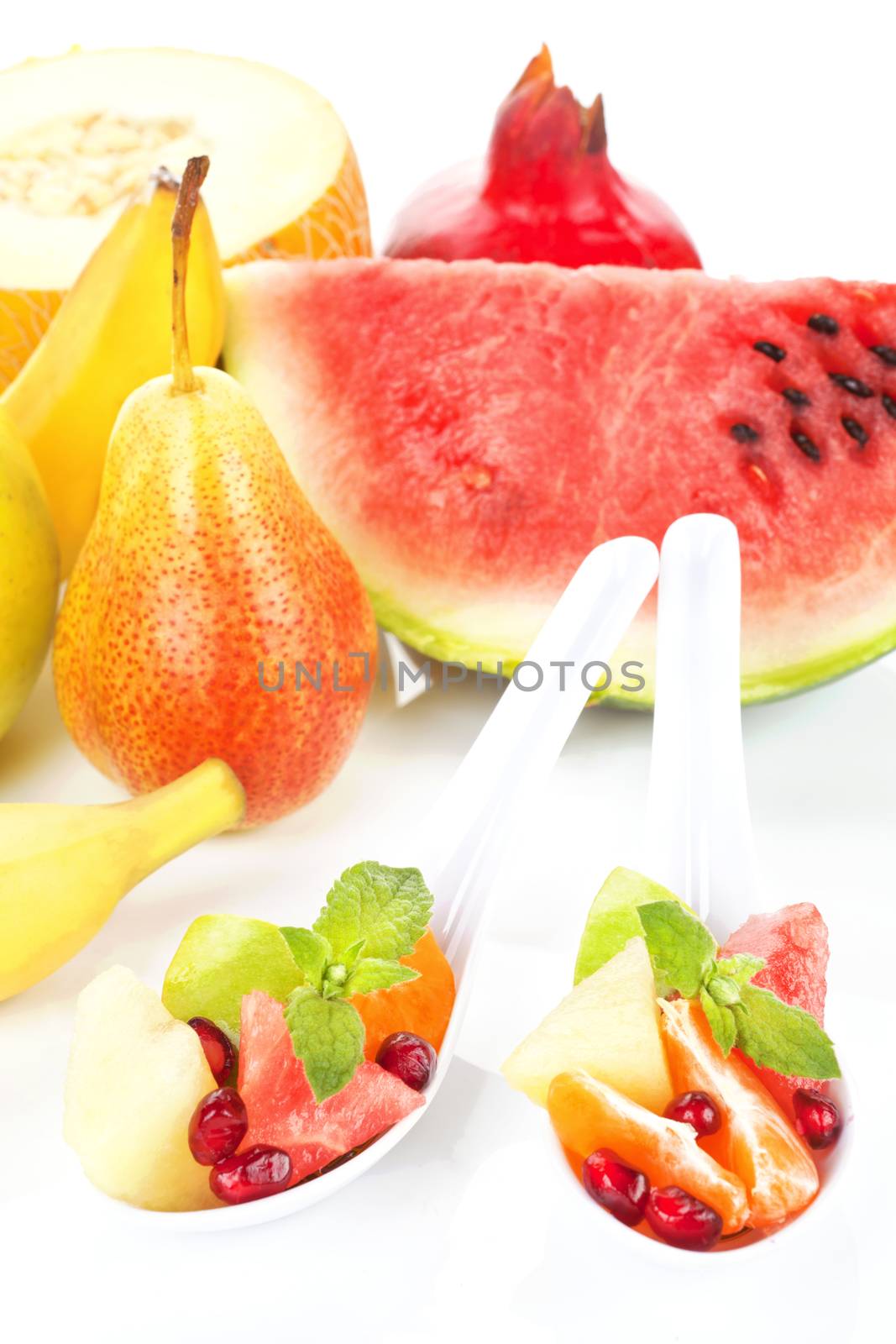 Fresh fruit pieces on two spoons, fruits in background isolated on white. Healthy background. In order to change we must be sick and tired of being sick and tired.