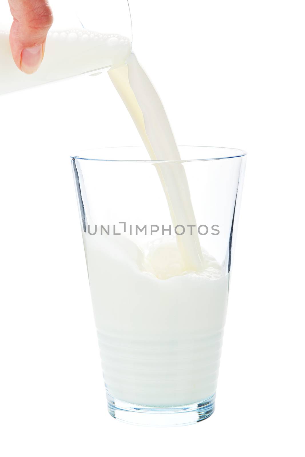 Pouring milk into glass isolated on white background with clipping path.