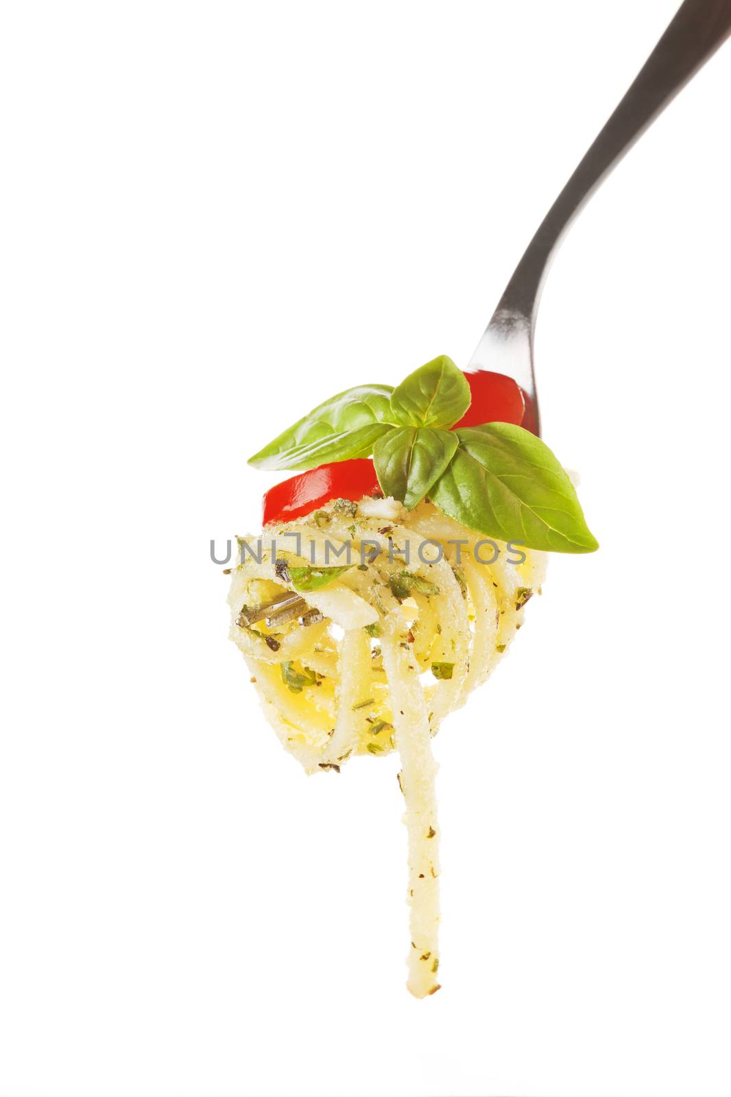 Pasta with tomato, pesto and fresh basil on fork isolated on white. 