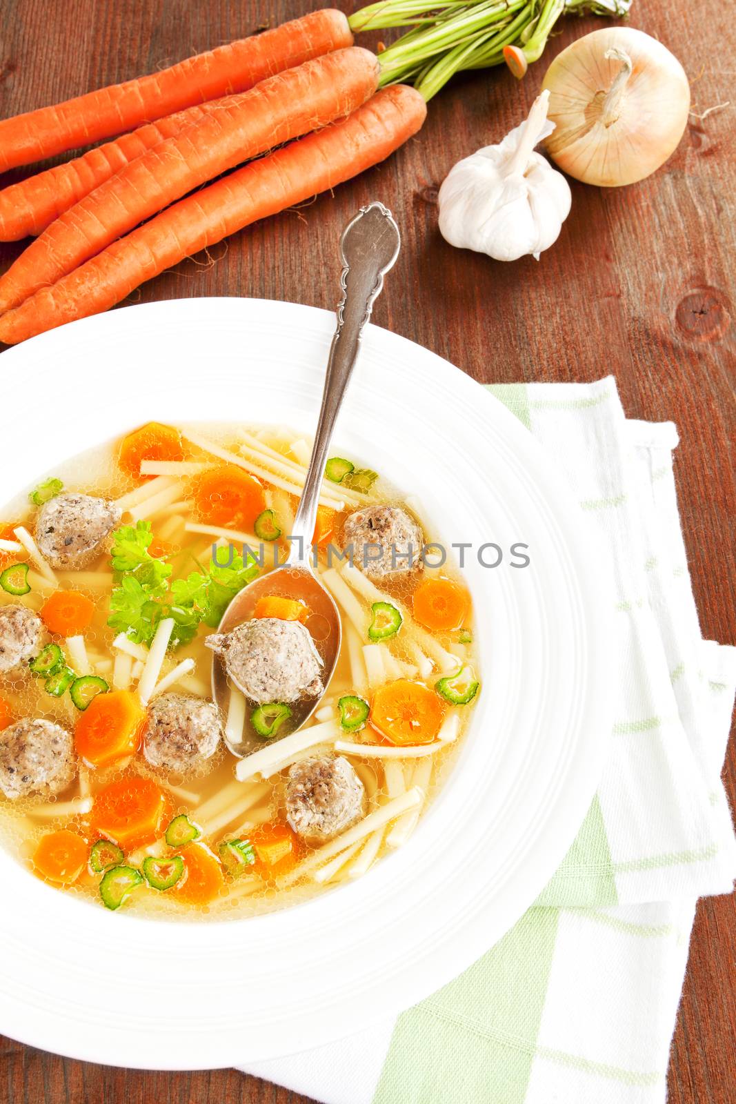 Delicious seasonal vegetable soup with fresh vegetables in the background. Healthy eating.