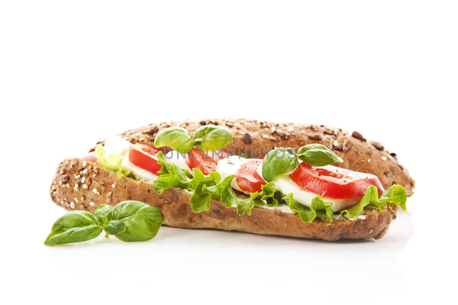 Tomato mozzarella baguette with fresh vegetable isolated on white background.