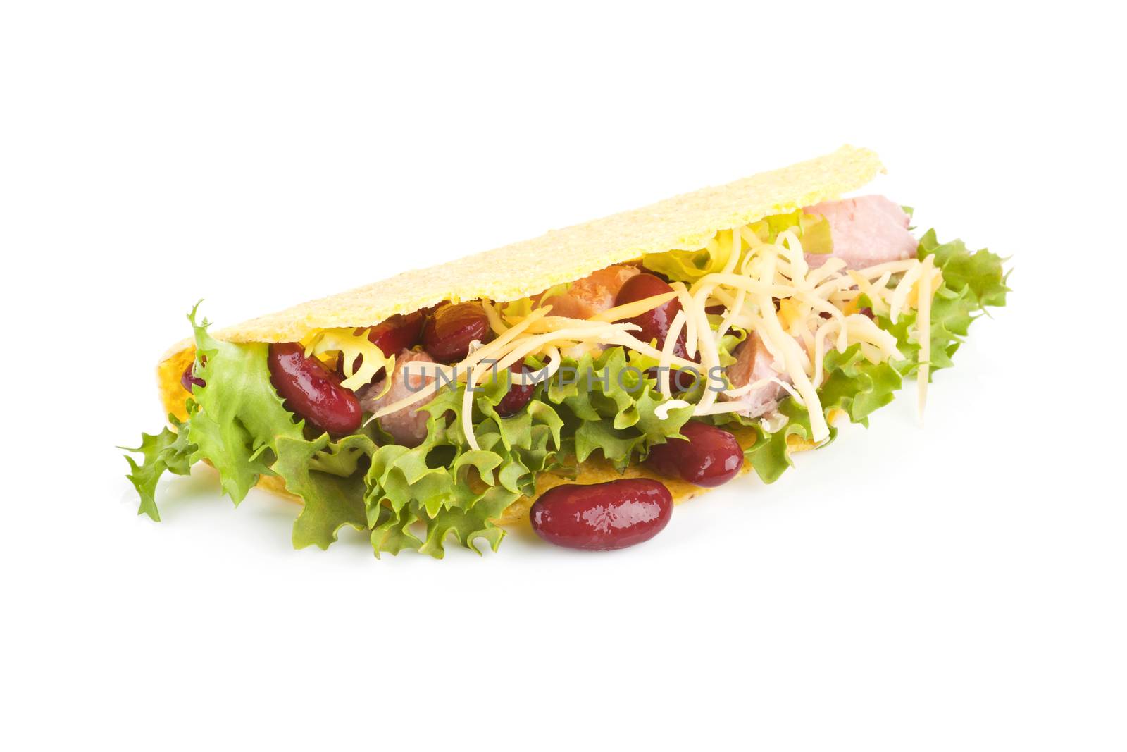 Taco with beans, ham, lettuce and grated cheese isolated on white.