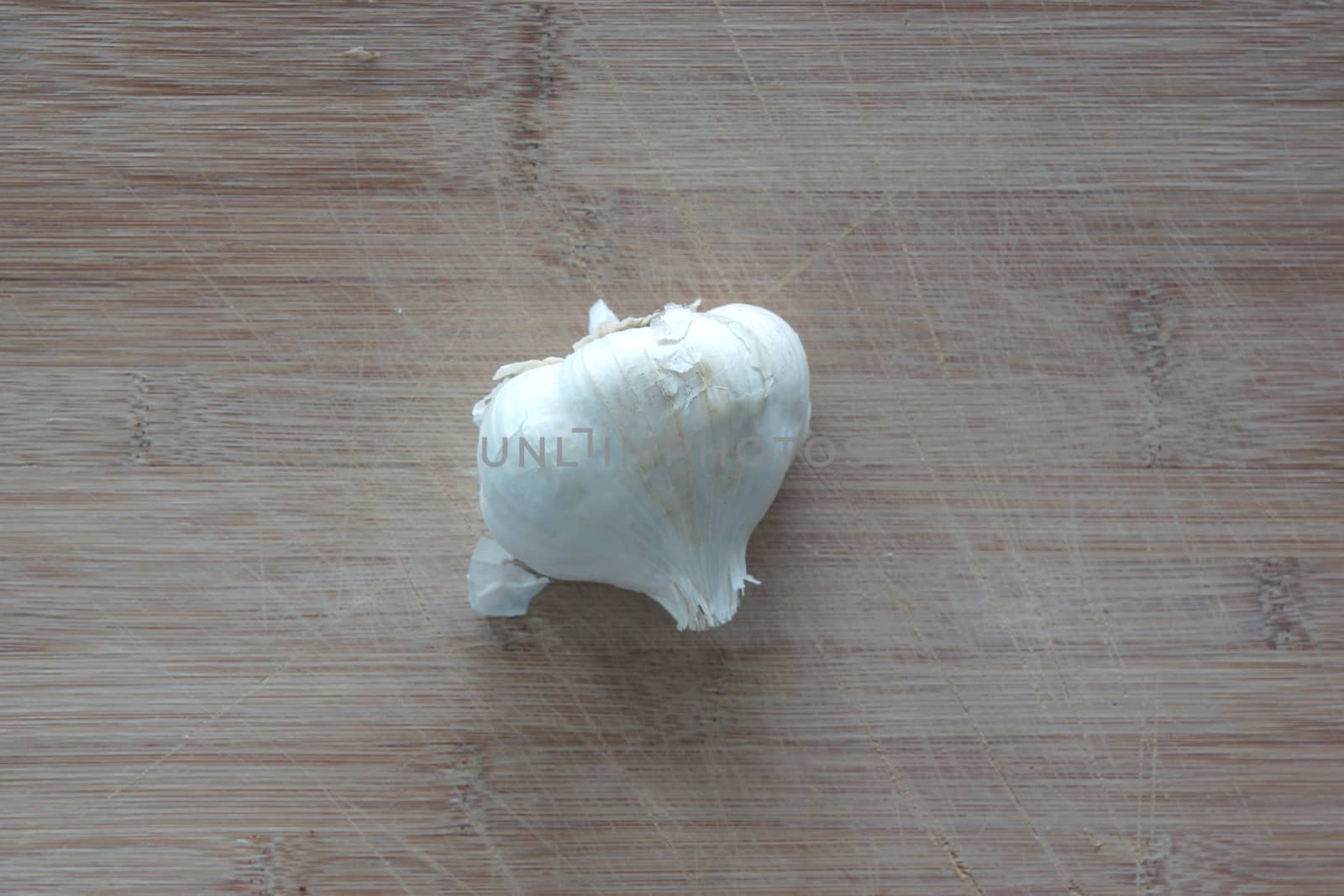 A clove of garlic on top of a cutting board