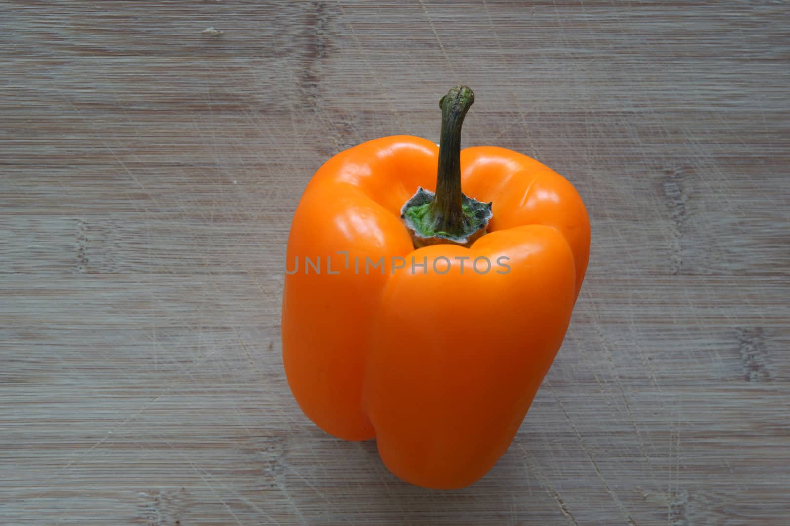 An orange bell pepper on top of a cutting board