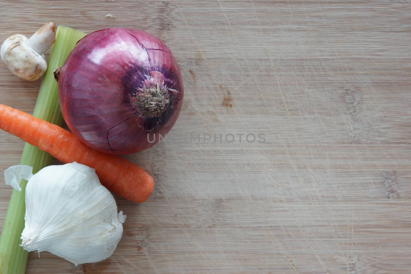 A group of vegetables on a wooden cutting board