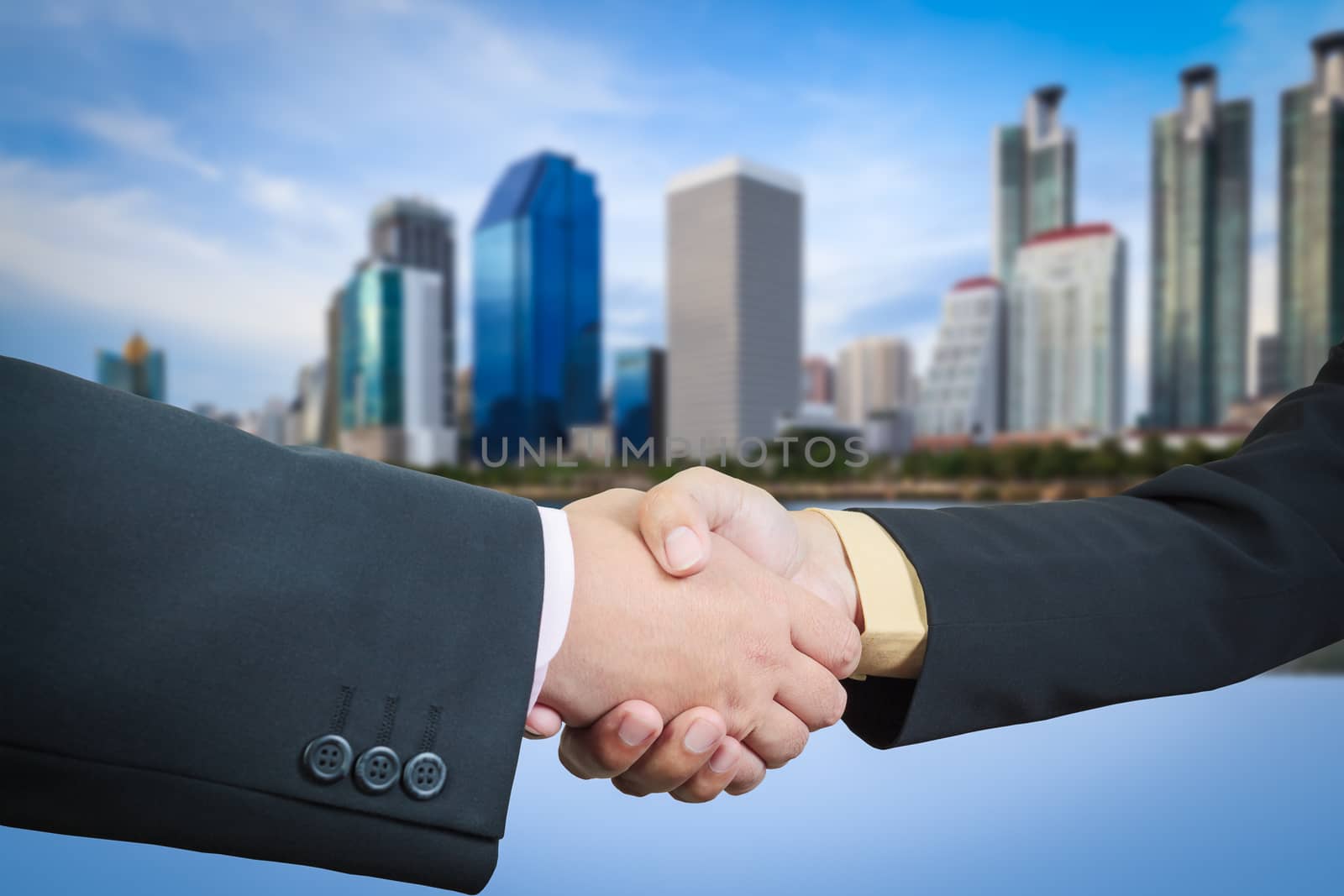 Businessman handshake with building area background
