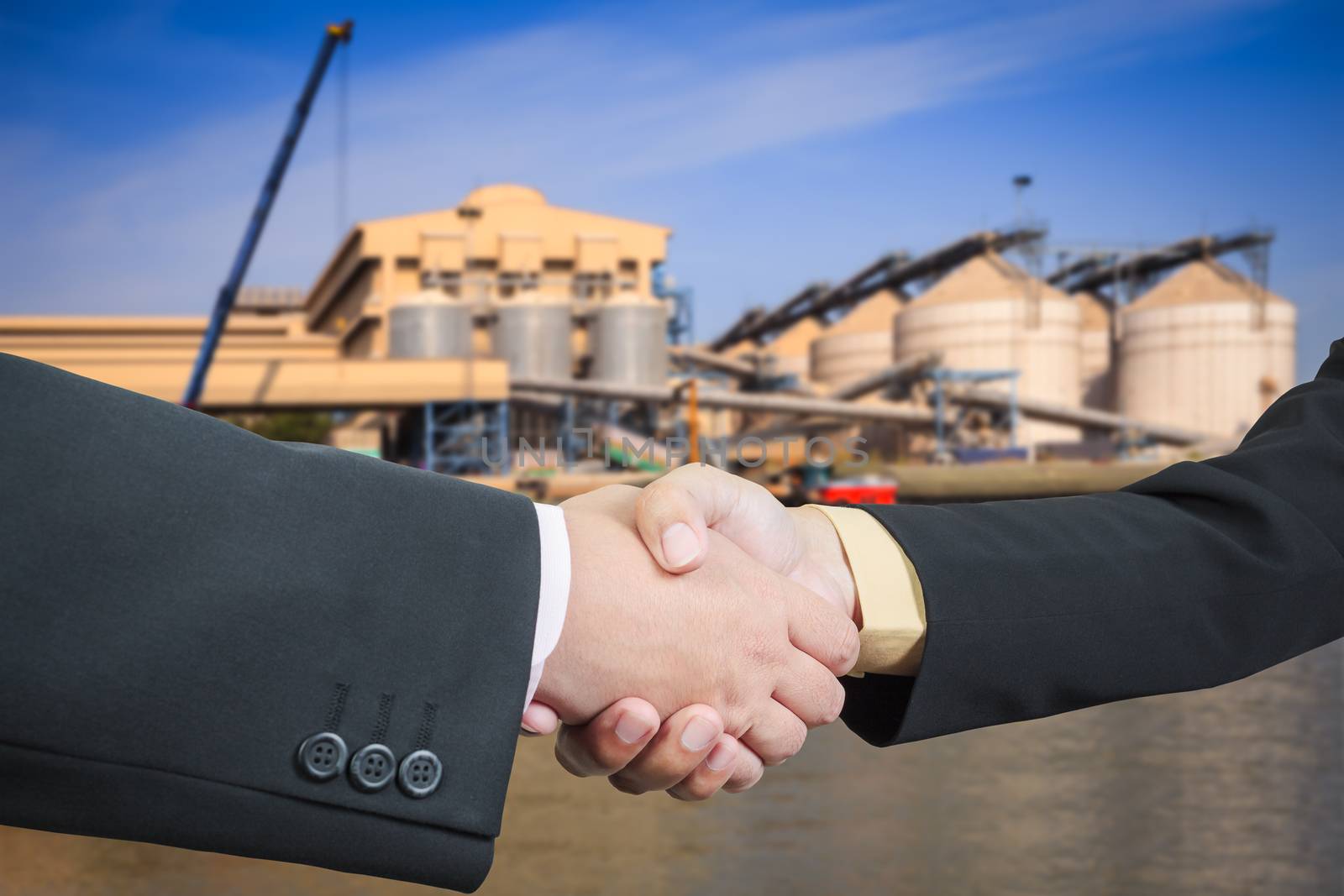 Businessman handshake with silo transportation logistic background
