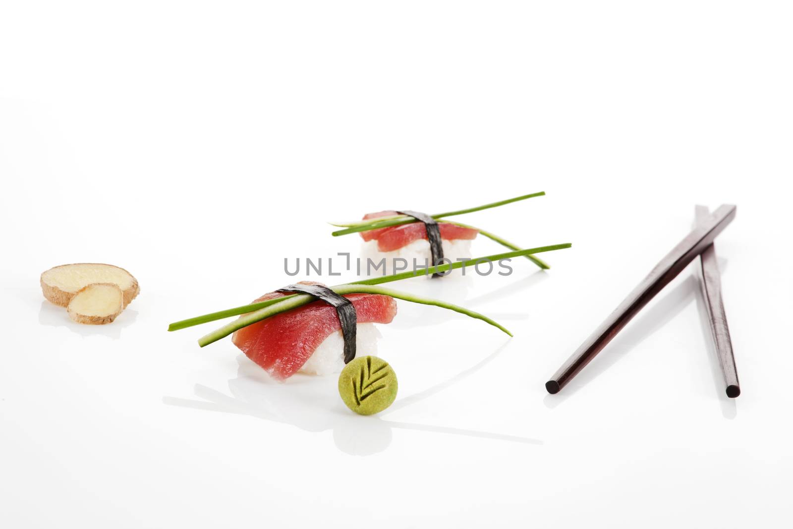 Sashimi sushi pieces with ginger, chopsticks, wasabi and chive isolated on white background.