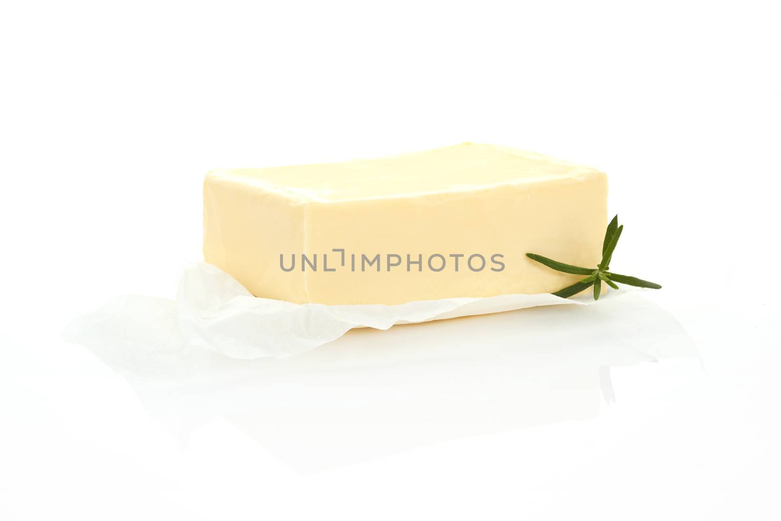 Butter on wrapping paper isolated on white background with rosemary herb.