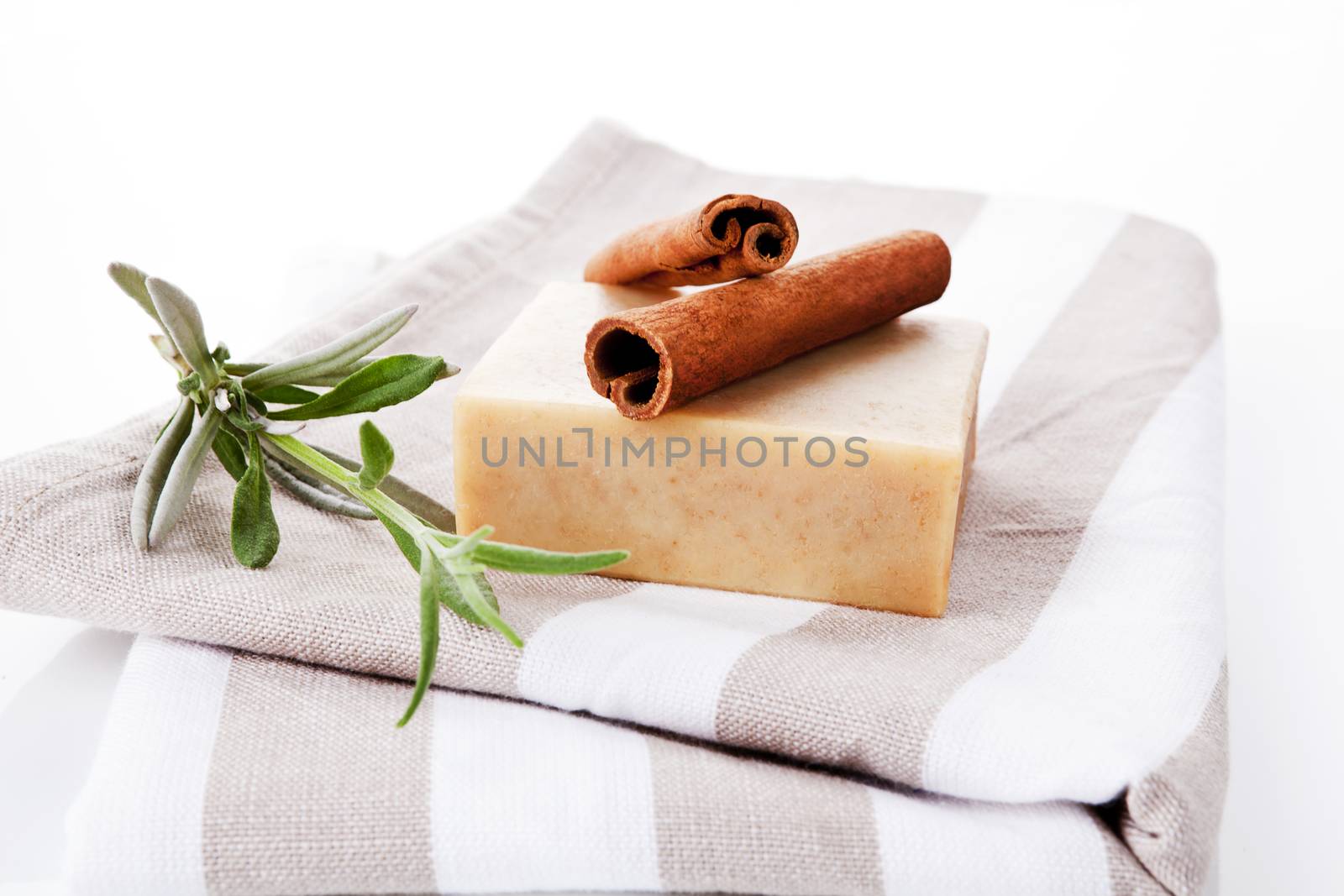 Body care background. Cinnamon soap bar and cinnamon on towel with fresh lavender.