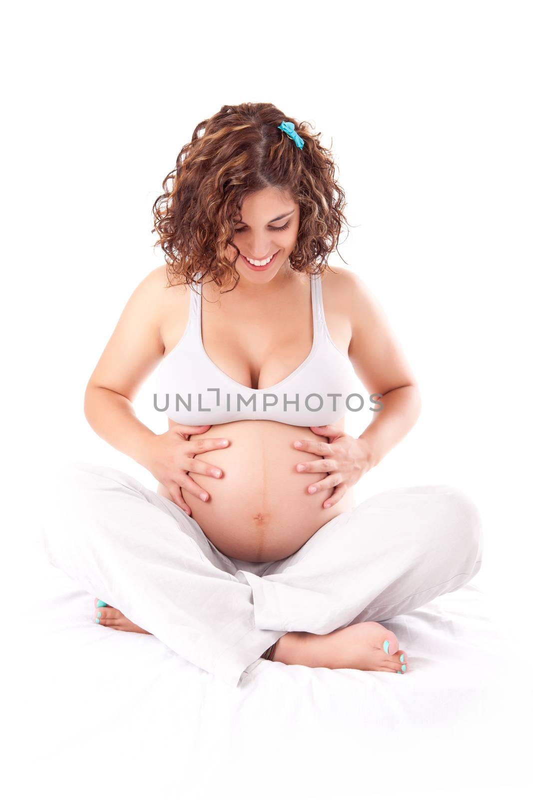 Beautiful pregnant woman showing her good shape over white background